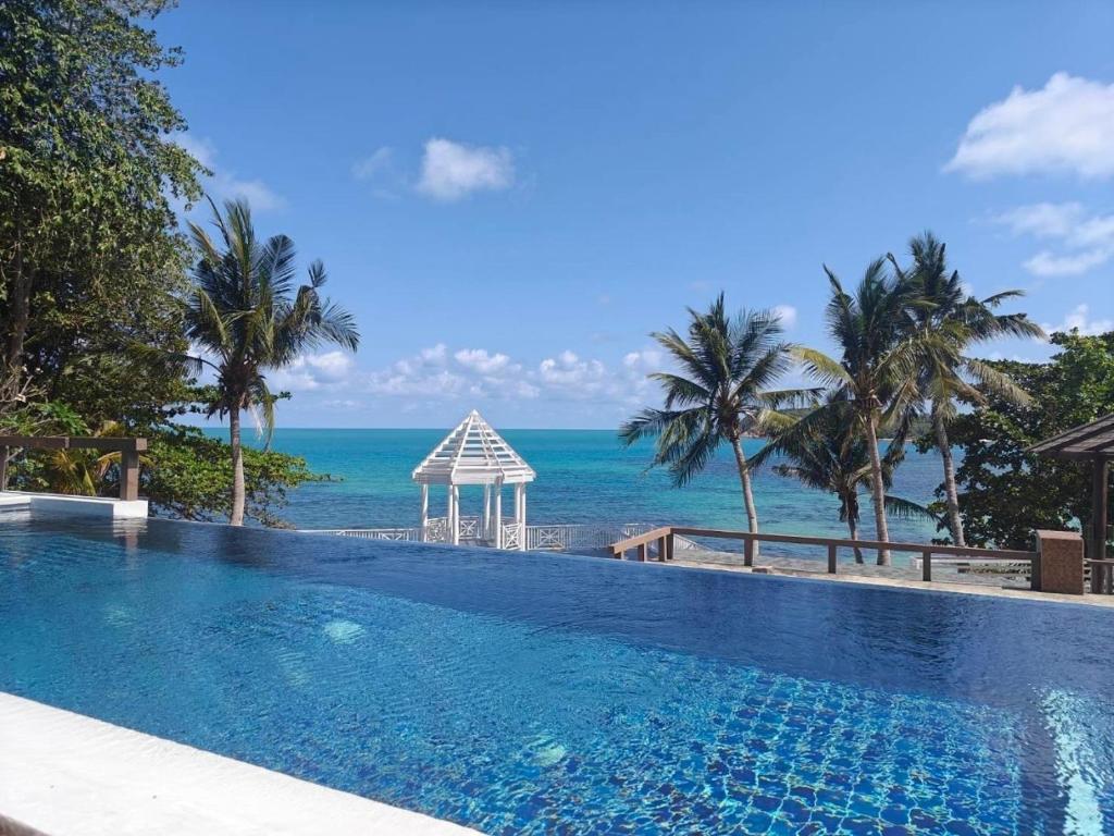 a swimming pool with a view of the ocean at Bhundhari Resort & Villas Samui in Chaweng