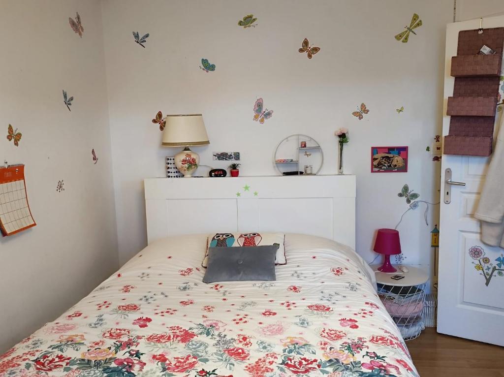 - une chambre dotée d'un lit avec un couvre-lit floral dans l'établissement Maison Guidel Plages 4 à 8 personnes, à Guidel