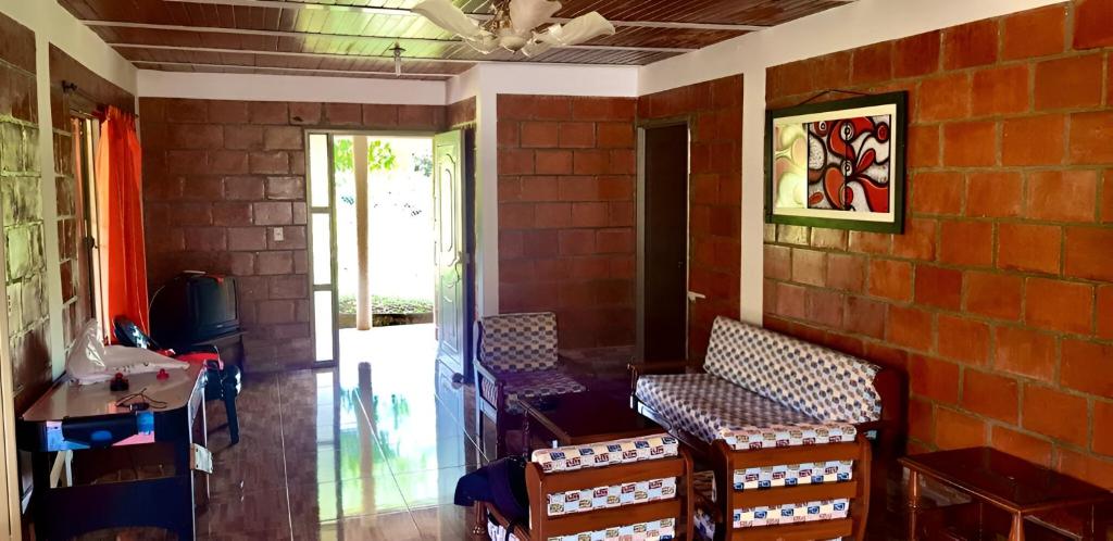 Habitación con 2 sillas y pared de ladrillo en Finca Villa Laila en La Cumbre