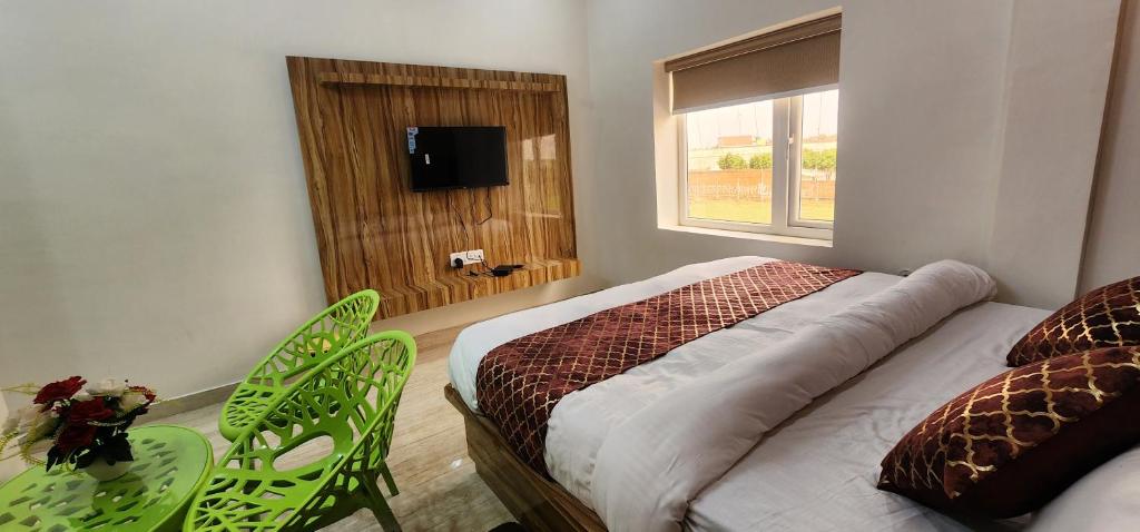 een slaapkamer met een bed en stoelen en een raam bij jsb hotel in Kakarmatha