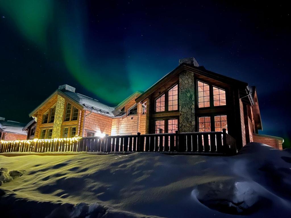 a house with the aurora in the sky at Idre Mountain Lodges with 11 beds in Idre