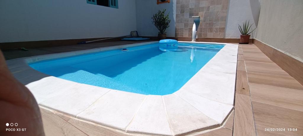 uma piscina com água azul num quarto em Casa 3 quartos 2 banheiros patio gramado fechado com piscina em Guarapari