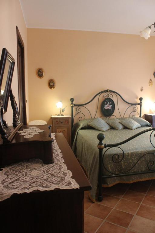 Schlafzimmer mit einem Bett, einem Spiegel und einem Tisch in der Unterkunft Al Borgo Antico in Forza dʼAgro