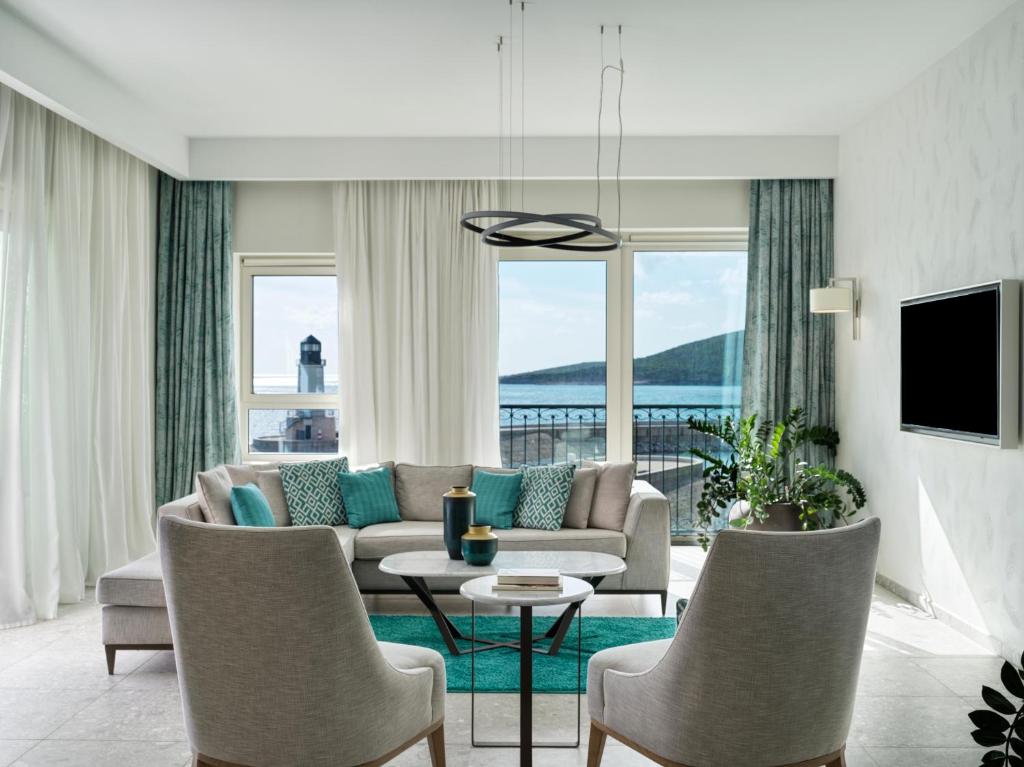 a living room with a couch and a table and chairs at The Chedi Luštica Bay in Tivat