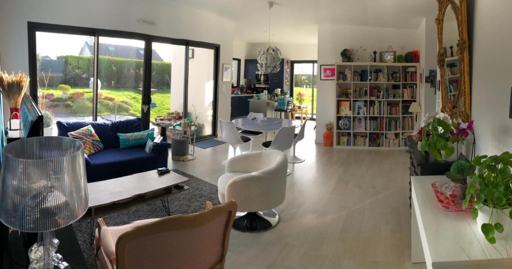 uma sala de estar com um sofá azul e cadeiras em Villa aux portes de la presqu'ïle de Crozon em Plomodiern