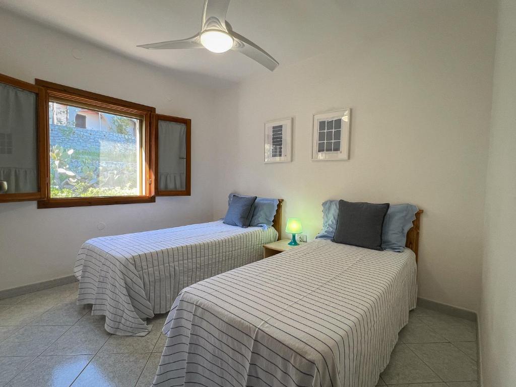マリーナ・ディ・カンポにあるcasa vacanze la palmaの窓のある部屋にベッドが2つある