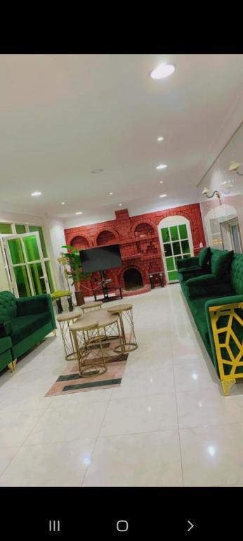 شالية مون لايت في أملج: غرفة معيشة مع أثاث أخضر ومدفأة