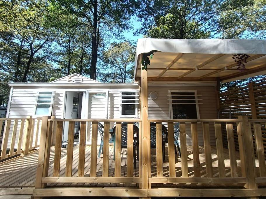 a house on a deck with a porch at Mobil-home, 3 ch , 6 personnes in Le Pont Legé