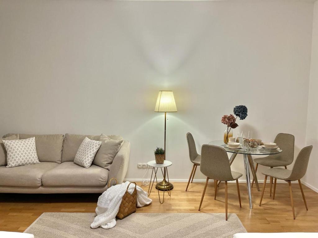 a living room with a couch and a table with chairs at Zentrales Apartment mit Balkon in Vienna