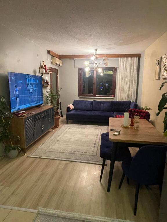 Lüx 1+1 merkez de daire في إسطنبول: غرفة معيشة مع أريكة زرقاء وتلفزيون