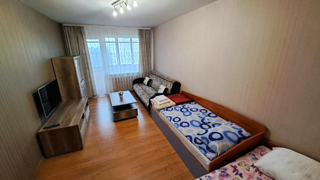ein kleines Wohnzimmer mit einem Sofa und einem TV in der Unterkunft Apartment Ramune in Šiauliai
