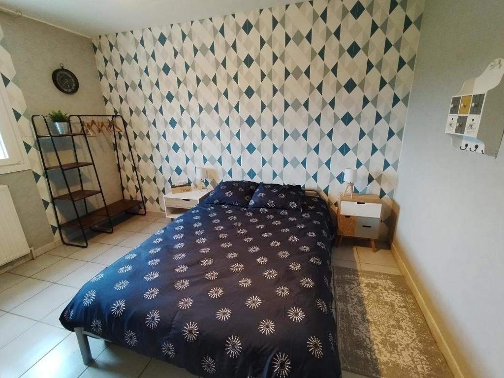 Un dormitorio con una cama azul y una pared en Chambre chez l'habitant avec Sdb et WC privatifs, en Marnay-sur-Seine