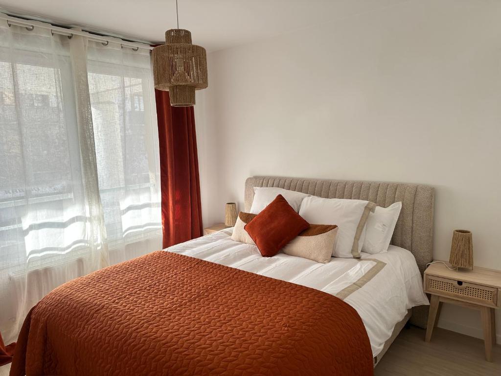 sypialnia z łóżkiem z pomarańczowymi i białymi poduszkami w obiekcie Annecy gare w Annecy