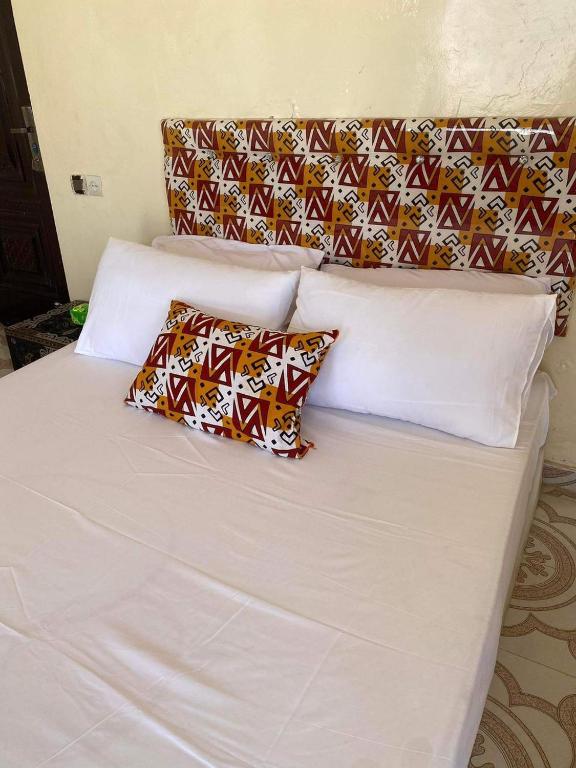 uma cama branca com duas almofadas em 2 bedroom appartement in the heart of nouakchott em Nouakchott