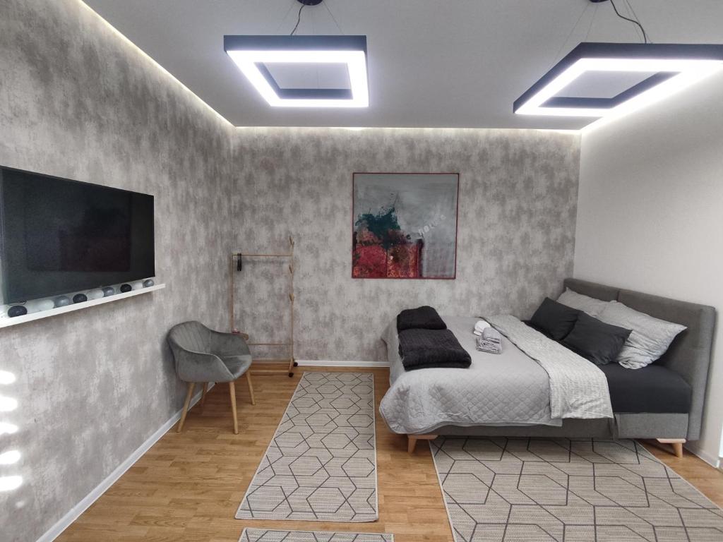a bedroom with a bed and a flat screen tv at Apartmani Park in Novi Pazar