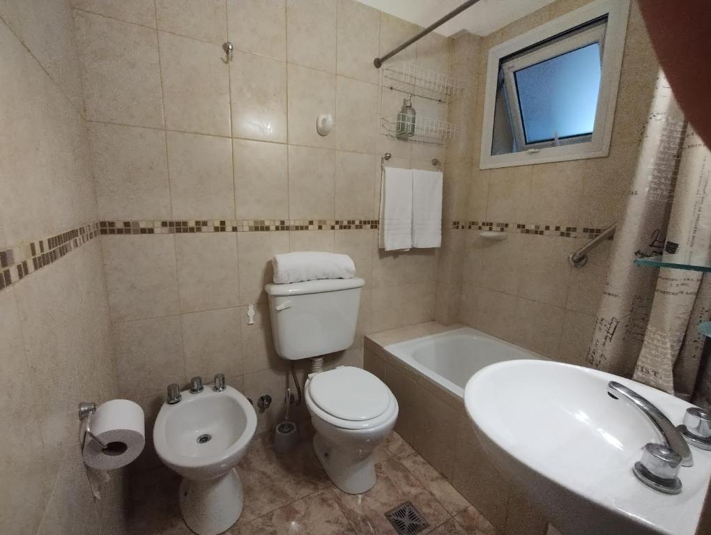 uma casa de banho com um WC, uma banheira e um lavatório. em Nacientes del Limay, Dina Huapi em Dina Huapi