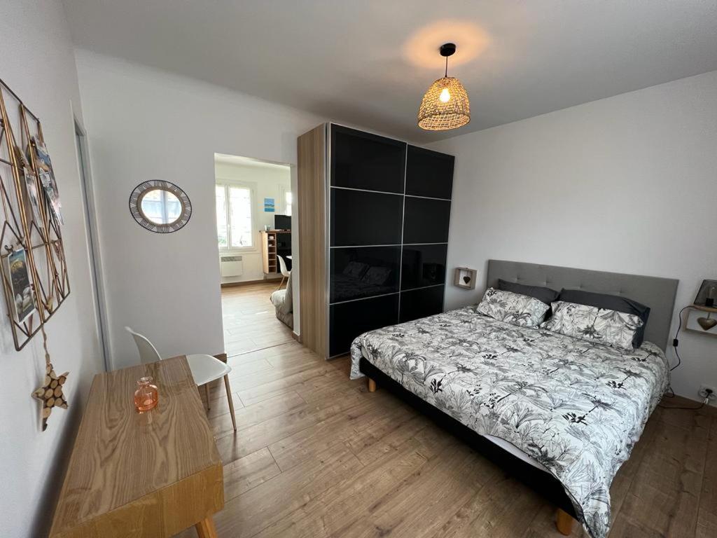a bedroom with a bed and a wooden floor at Appartement proche plage et commerces in Royan