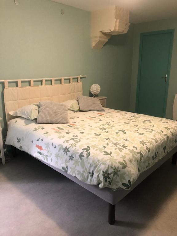 1 Schlafzimmer mit einem Bett mit Blumendecke in der Unterkunft Les chambres du Moulin in Les Epsailles
