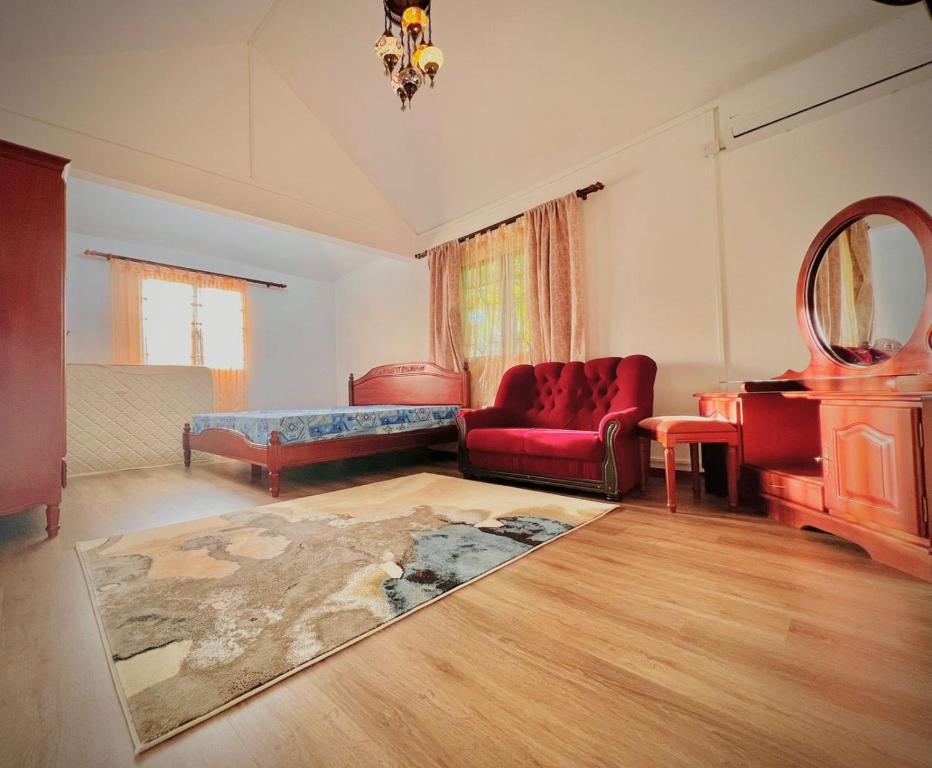 a living room with a red couch and a mirror at N.Caunhye Villa in Pereybere