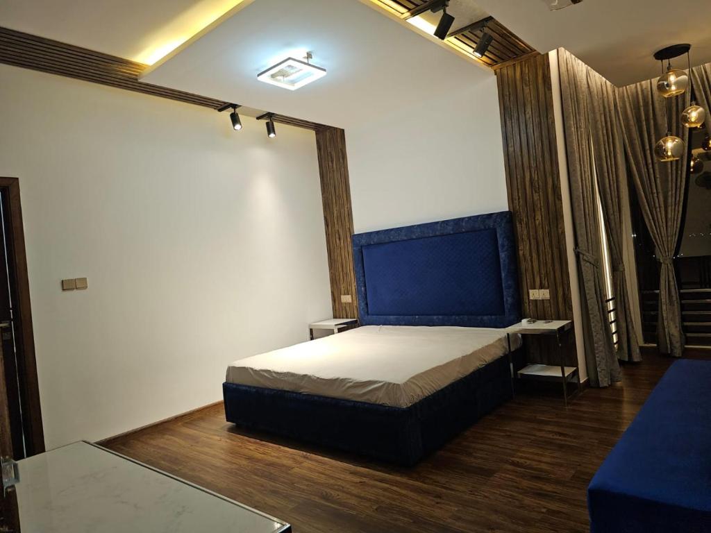 a bedroom with a bed with a blue headboard at Villa Ajaman in Ajman 