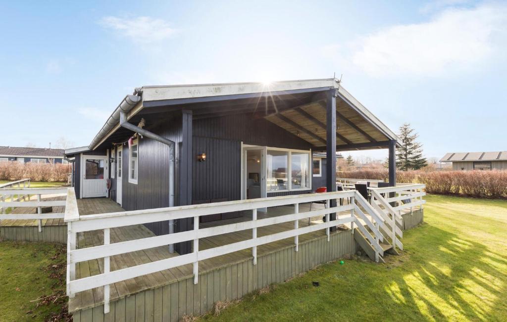 una casita negra con una valla blanca en Cozy Home In Glesborg With Kitchen, en Glesborg