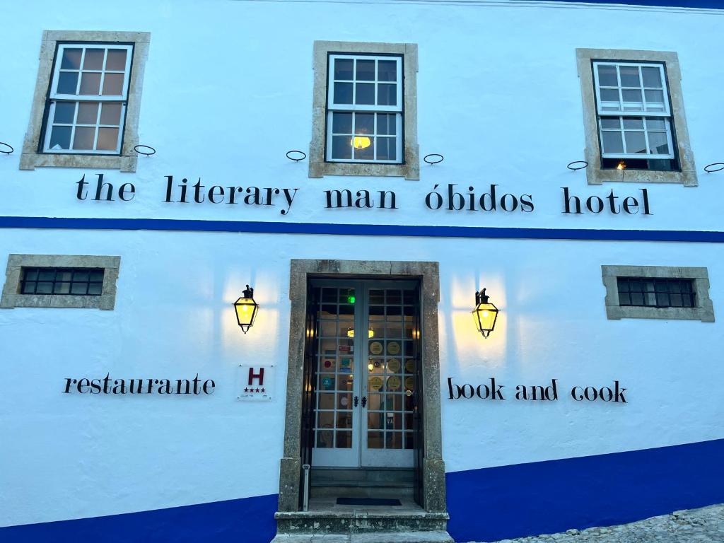 a white building with a sign that reads the literary main manildo hotel at The Literary Man Obidos Hotel in Óbidos