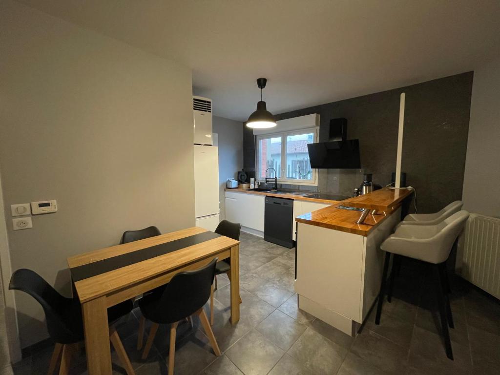 une petite cuisine avec une table, une table et des chaises dans l'établissement Appartement T3 proche centre ville, à La Teste-de-Buch