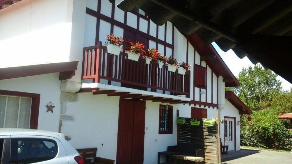 UrcuitにあるLocation appartement dans Maison Basqueの花が咲くバルコニー付きの建物
