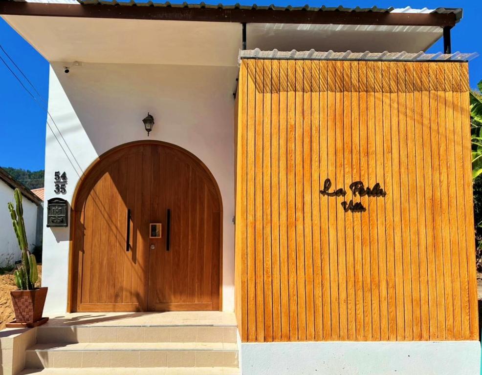 eine Holztür an der Seite eines Hauses in der Unterkunft 2BR Pool Villa&Garden - Bali style by La Perla Phuket Rawai in Ban Saiyuan (1)