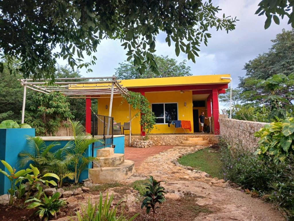ein Haus mit gelber und blauer Fassade in der Unterkunft Casita Amarilla in the Yellow City in Izamal