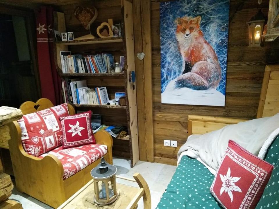 a living room with a couch and a picture of a squirrel at Le refuge du poète in Saint-François-de-Sales