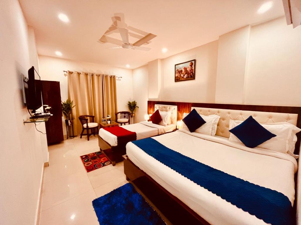 pokój hotelowy z 2 łóżkami i telewizorem w obiekcie Hotel The Pacific Paradise w mieście Haridwar