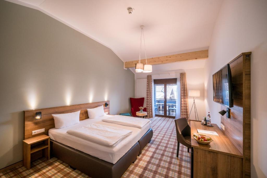 sypialnia z dużym łóżkiem i telewizorem w obiekcie Hotel Kühbergalp w mieście Gunzesried