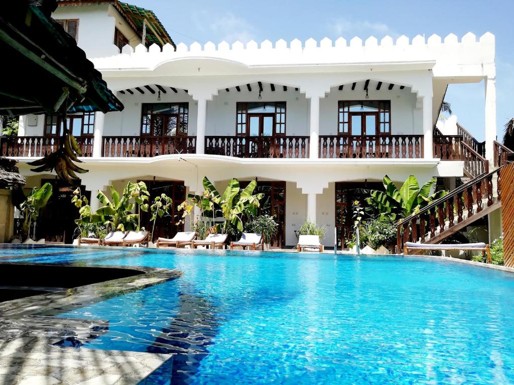 a swimming pool in front of a house at The New Blue Waves Hotel in Jambiani