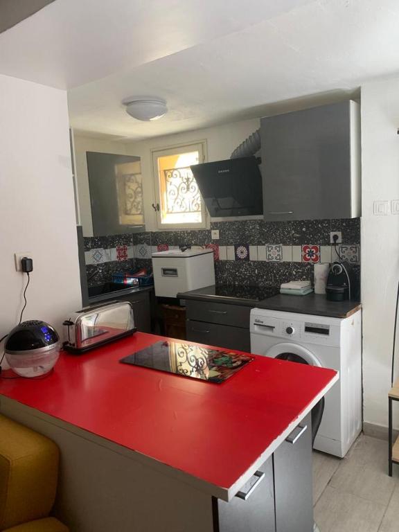 uma cozinha com um balcão vermelho num quarto em Le first em Grasse