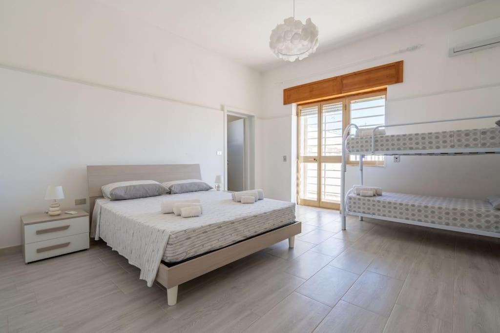 Un dormitorio blanco con una cama grande y una ventana en Villetta Rosa House 100 meters from the blue sea, en San Pietro in Bevagna