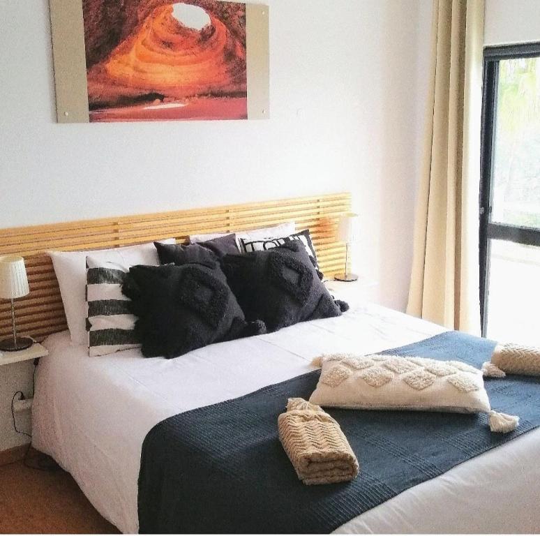 a bedroom with a large bed with a blanket on it at Vila ALEGRIA CH2 in Estói