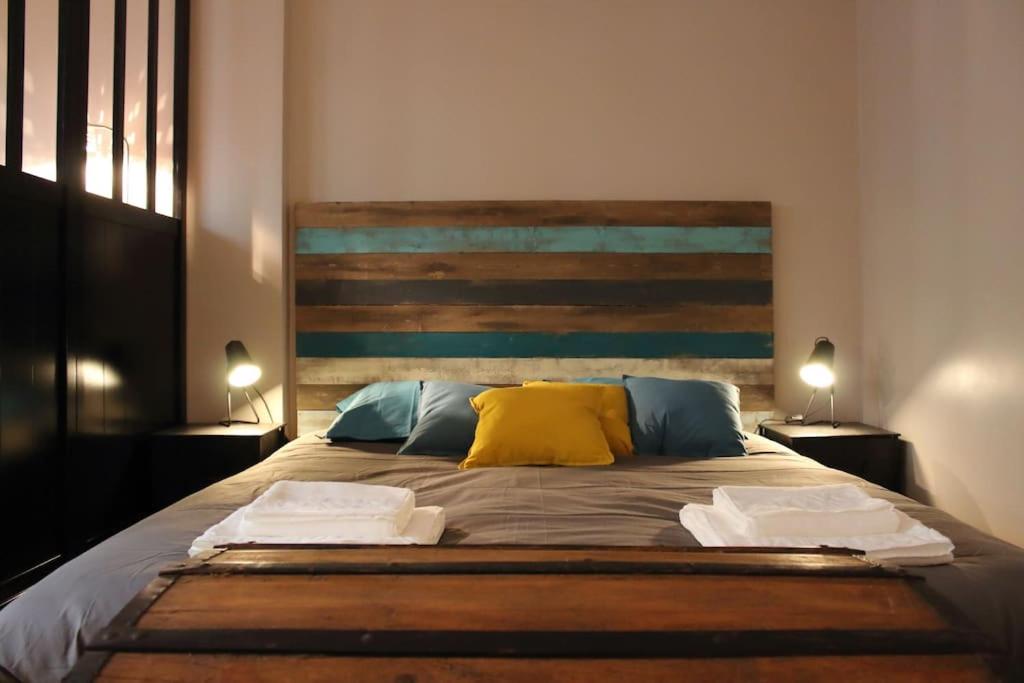 une chambre avec un grand lit avec une tête de lit en bois dans l'établissement Studio calme et accueillant Metro Charonne, à Paris