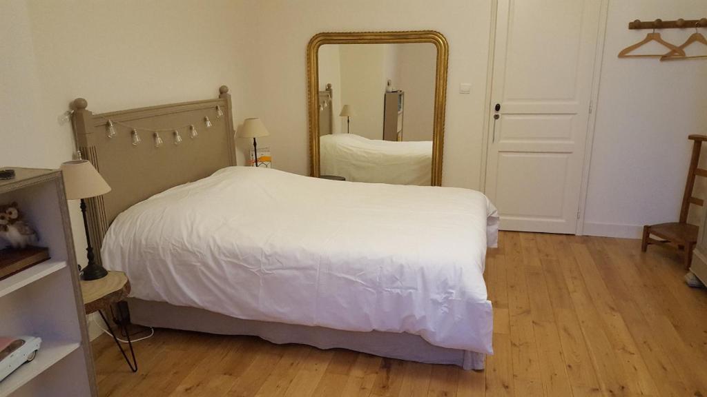 - une chambre avec un lit blanc et un grand miroir dans l'établissement Chb double avec baignoire, au Mans
