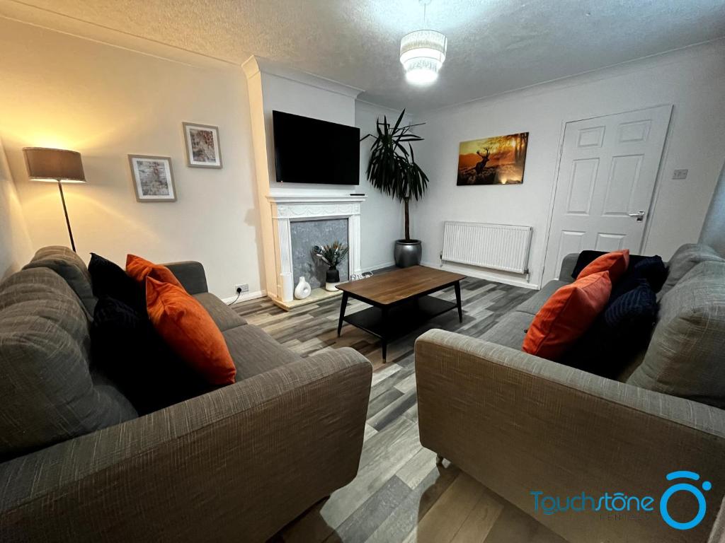 a living room with two couches and a table at Large Cosy Home - B'ham, Solihull, NEC, M42, HS2 in Birmingham