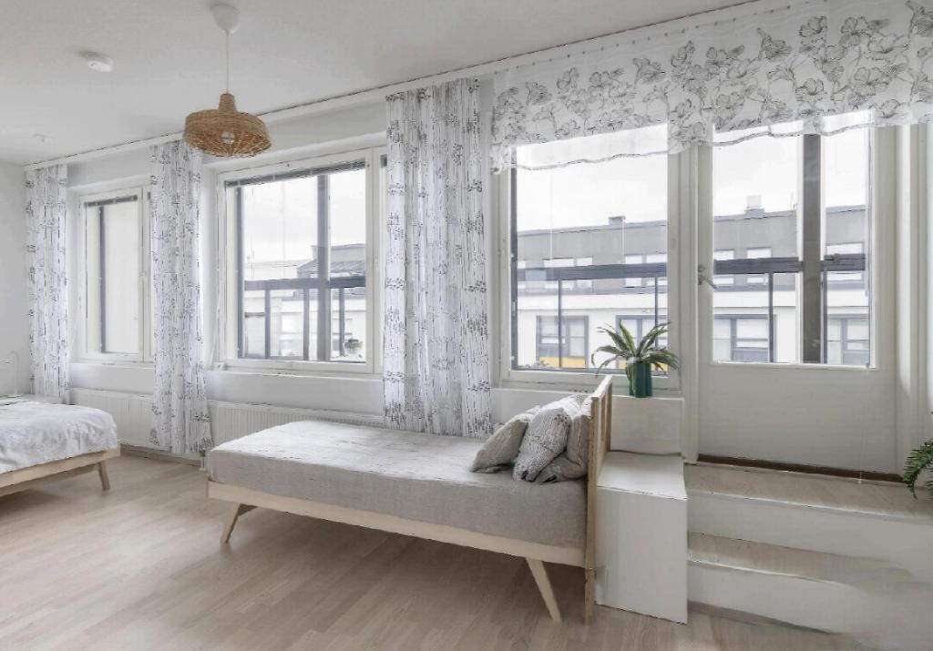 a bedroom with a bed and a window with curtains at Beautiful Modern City Apartment in Kuopio