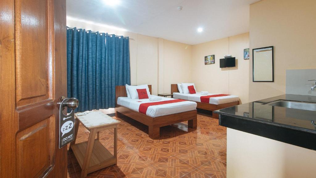 a hotel room with two beds and a sink at RedDoorz at Casa Buena Dormitel Davao City in Davao City
