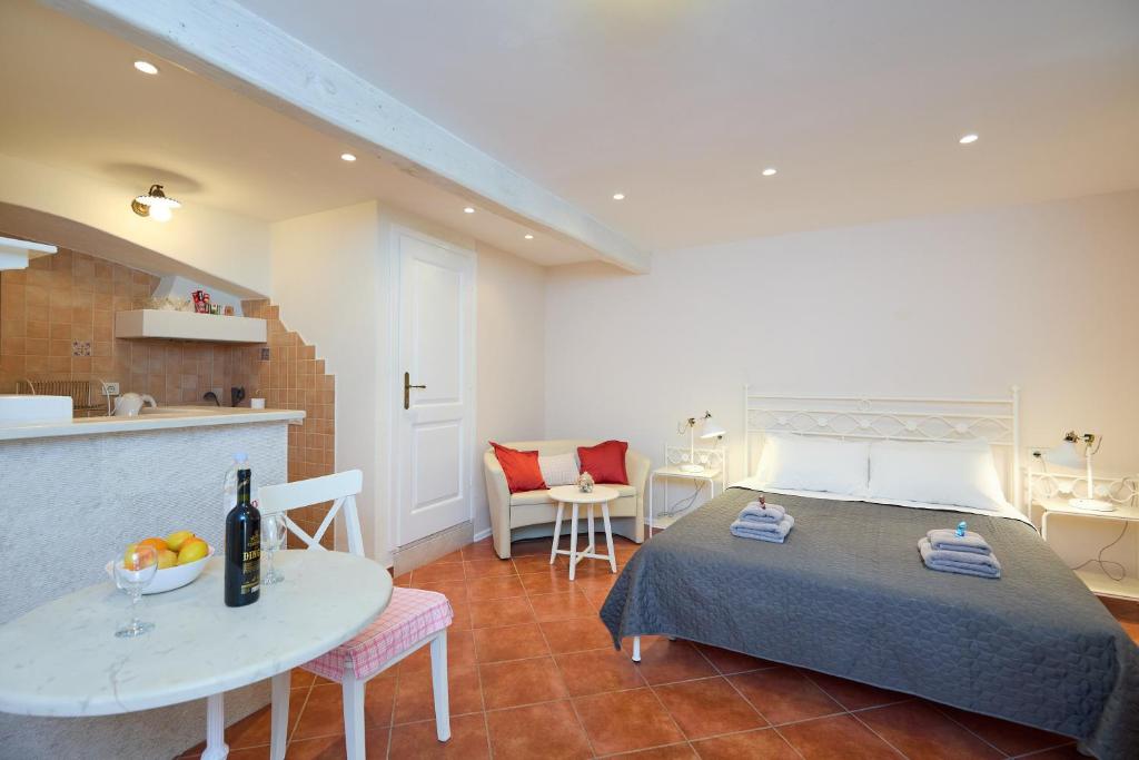 Cet appartement comprend une chambre avec un lit et une table ainsi qu'une cuisine. dans l'établissement Doria Apartments, à Dubrovnik