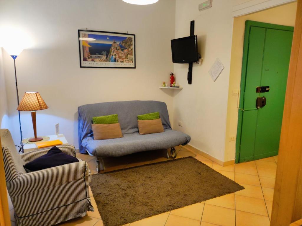 een woonkamer met een blauwe stoel en een groene deur bij Caio Asinio Apartment in Napels