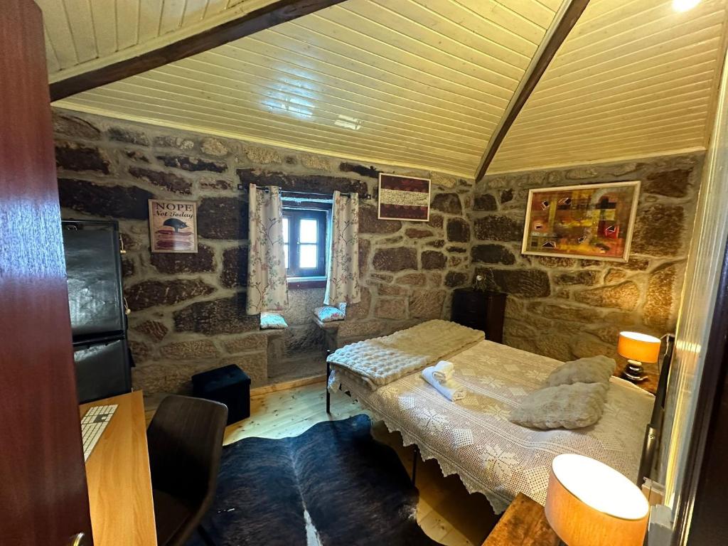 um quarto com duas camas num quarto de pedra em Casa da Eira 
