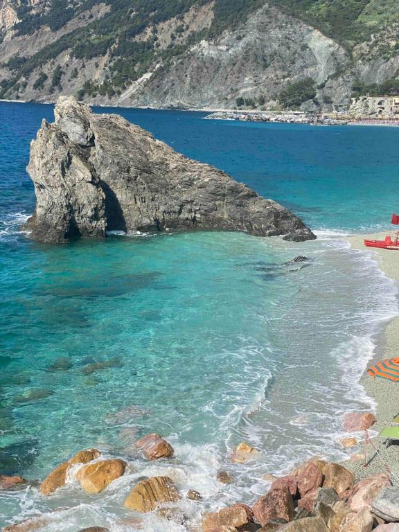 a beach with a large rock in the water at Affittacamere Benvenuti Monterosso in Monterosso al Mare