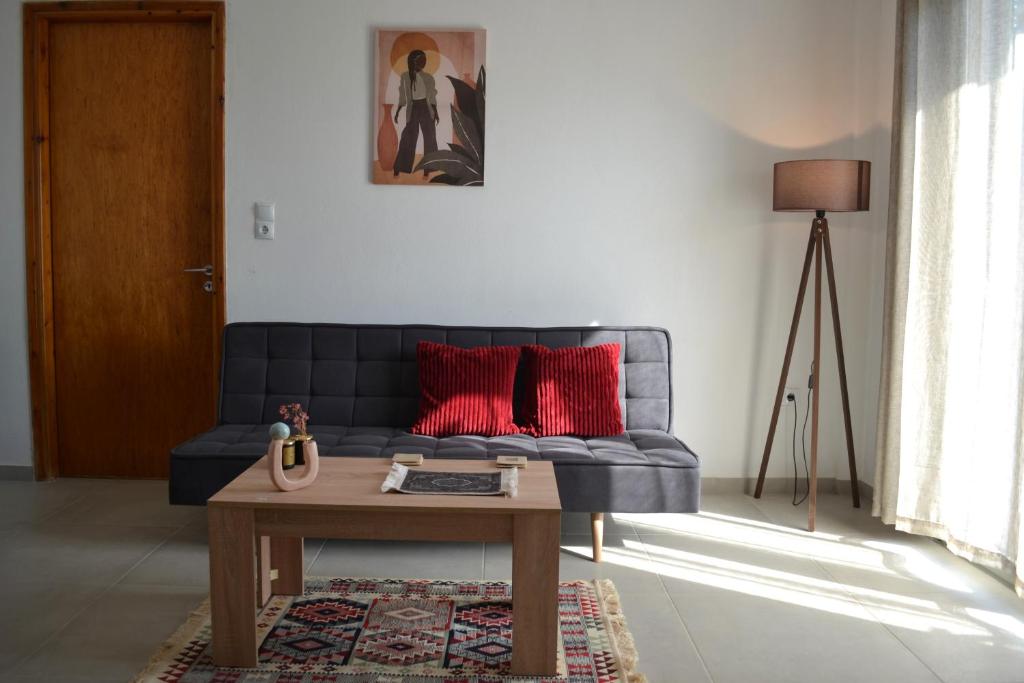 ein Wohnzimmer mit einem blauen Sofa und einem Couchtisch in der Unterkunft Loupino Couples Romance in Stoupa