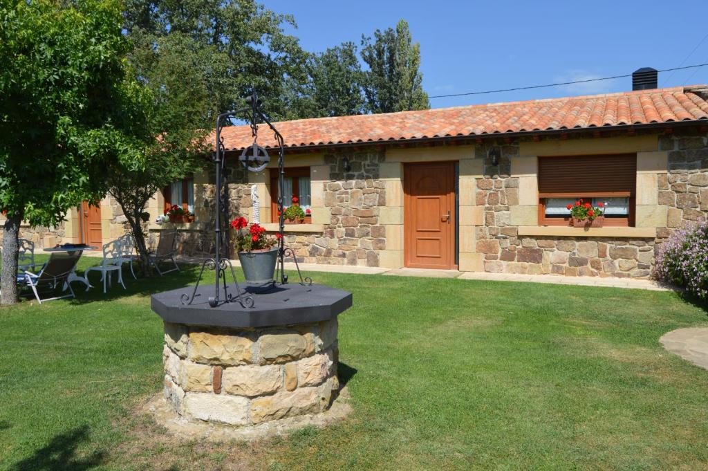 une petite maison en pierre avec une cour dans l'établissement La Casa del Rio - La Lobera Casa Rural, à Molinos de Razón