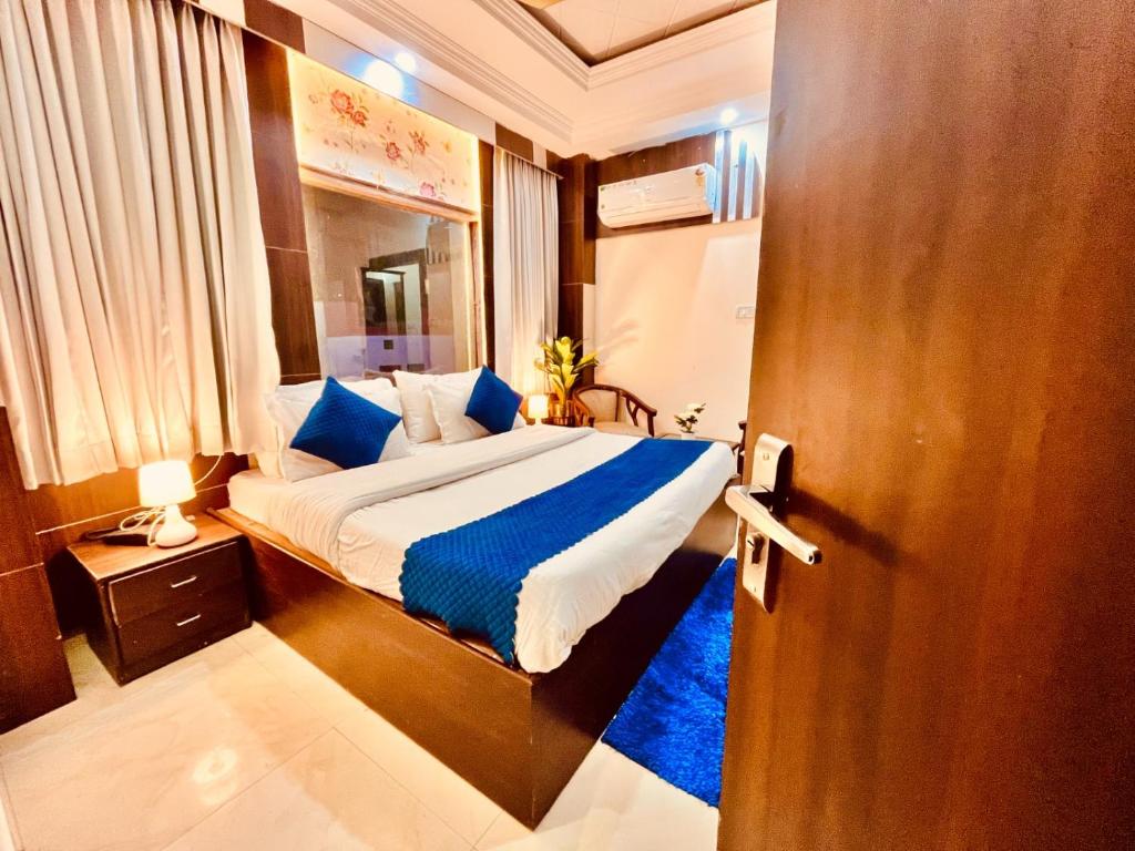 a bedroom with a large bed with blue pillows at Hotel Ramawati - A Luxury Hotel In Haridwar in Haridwār