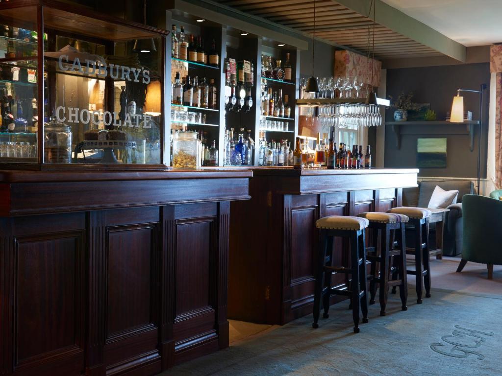 a bar with bar stools in a restaurant at Gregans Castle Hotel in Ballyvaughan
